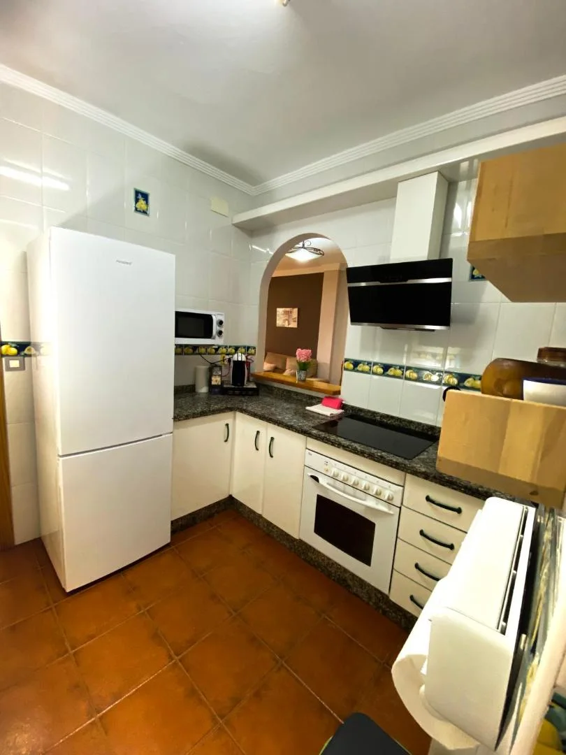 Cocina blanca con frigorífico, horno y microondas