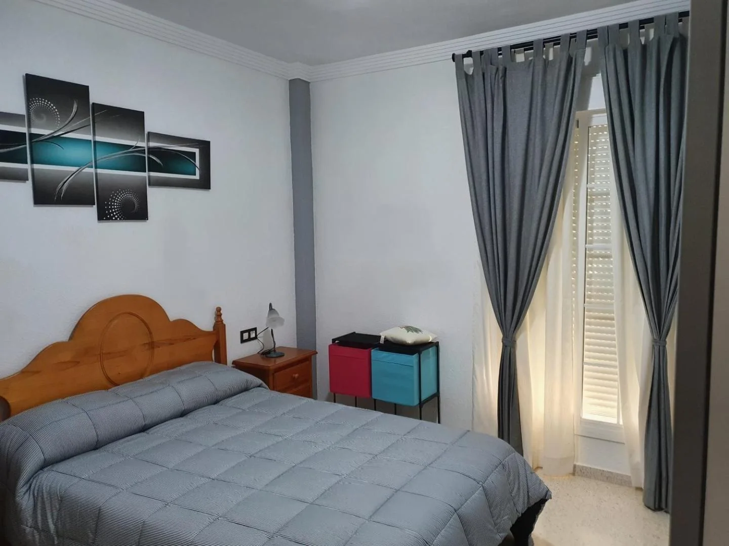 Dormitorio con cama y cortinas grises